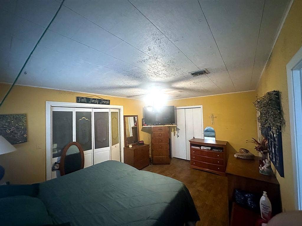 305 McKay Road, Burnet, TX 78611 Interior space featuring wood-finish flooring, white paneled closet doors, and a ceiling-mounted light fixture