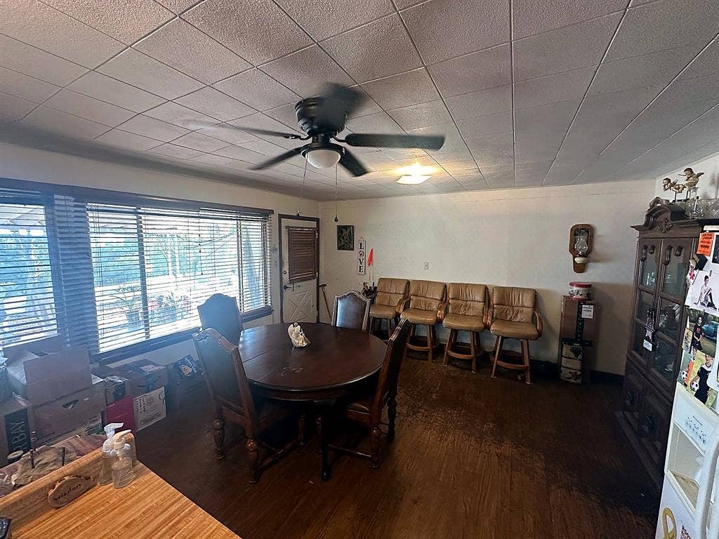 305 McKay Road, Burnet, TX 78611 Spacious room featuring wood-finish flooring, a ceiling fan, and large windows with horizontal blinds