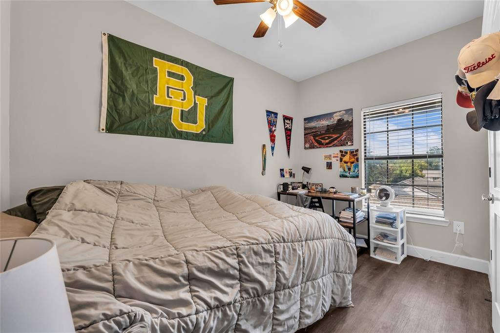2410 S 2nd Street, #625, Waco, TX 76706 Neutral-toned interior room featuring wood-finish flooring, a multi-blade ceiling fan with integrated lighting, and a window with horizontal blinds
