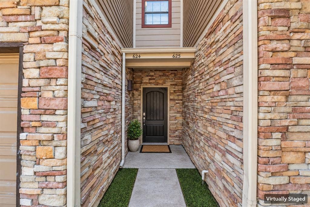 2410 S 2nd Street, #625, Waco, TX 76706 Stacked-stone exterior facade featuring a covered entryway, arched panel door, and concrete walkway