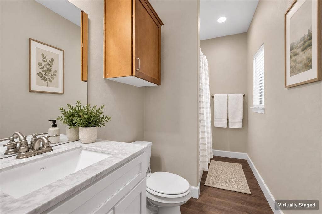 2410 S 2nd Street, #625, Waco, TX 76706 Bathroom featuring a vanity with a stone-finish countertop, undermount sink, dual-handle faucet, wall-mounted wood cabinet, and wood-finish flooring