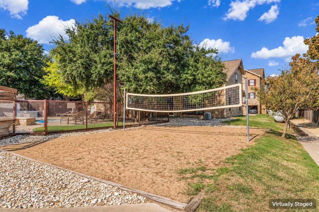 2410 S 2nd Street, #625, Waco, TX 76706 Sand volleyball court featuring a permanent net system, gravel perimeter, and metal fencing