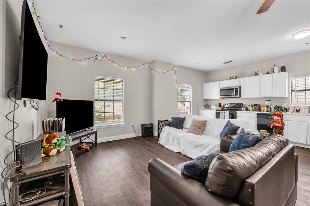 2410 S 2nd Street, #625, Waco, TX 76706 Open-concept living space featuring wood-finish flooring, recessed lighting, and white kitchen cabinetry with integrated appliances