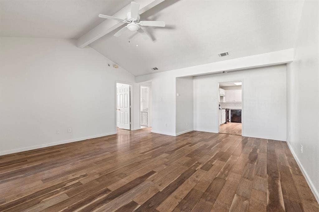 8406 Lullwater Drive, Dallas, TX 75218 Vaulted ceilings featuring a white beam, wood-finish flooring, and a white ceiling fan with integrated lighting