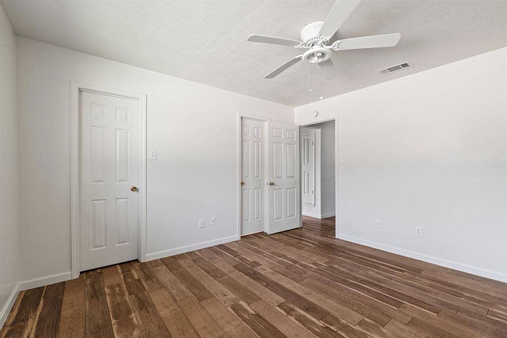 8406 Lullwater Drive, Dallas, TX 75218 Wood-finish flooring, white paneled interior doors, and a ceiling-mounted fan with integrated lighting