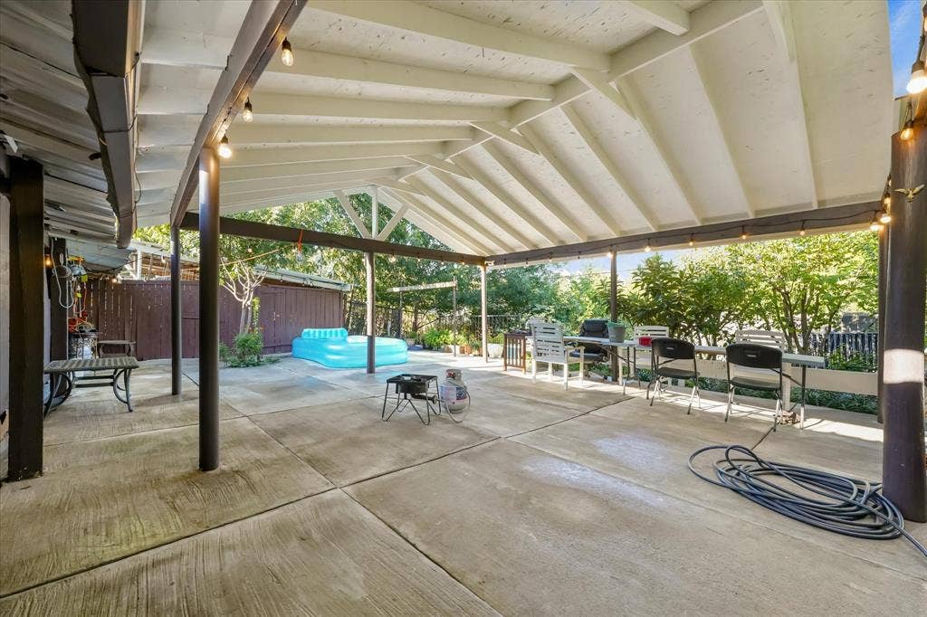 201 Glenridge Drive, Mesquite, TX 75149 Covered patio featuring a vaulted ceiling with exposed beams, concrete flooring, and metal support posts