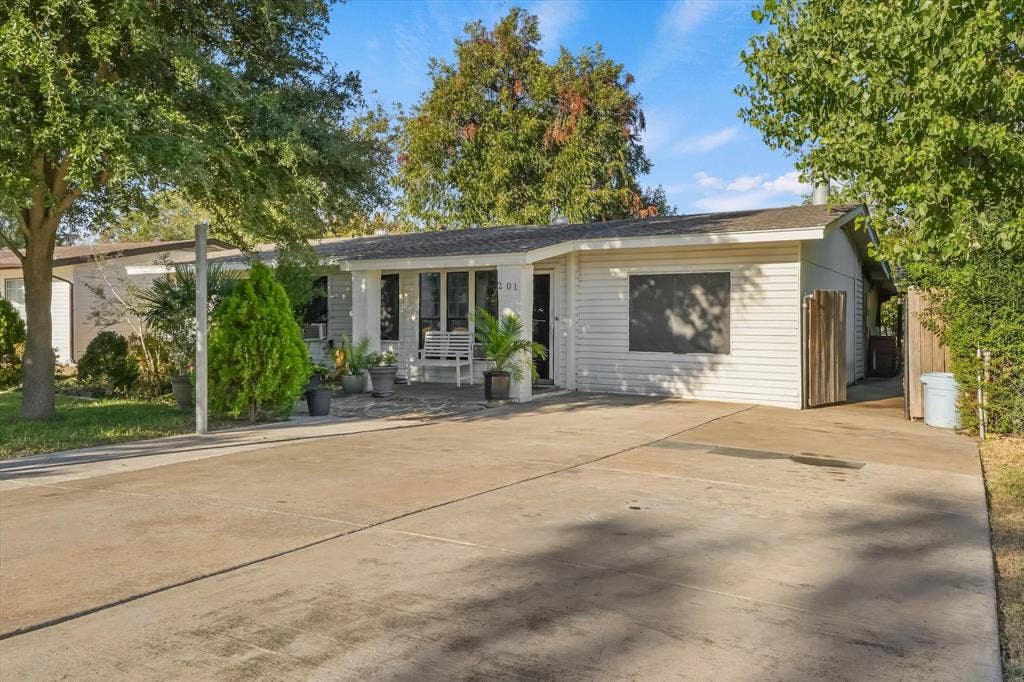201 Glenridge Drive, Mesquite, TX 75149 Single-story exterior featuring white horizontal siding, a concrete driveway, a covered front porch, and mature trees