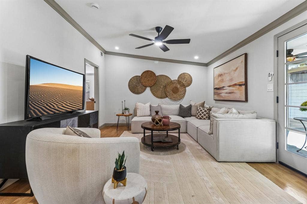 Wood-finish flooring, recessed lighting, crown molding, ceiling fan with integrated lighting, and a glass-paneled door