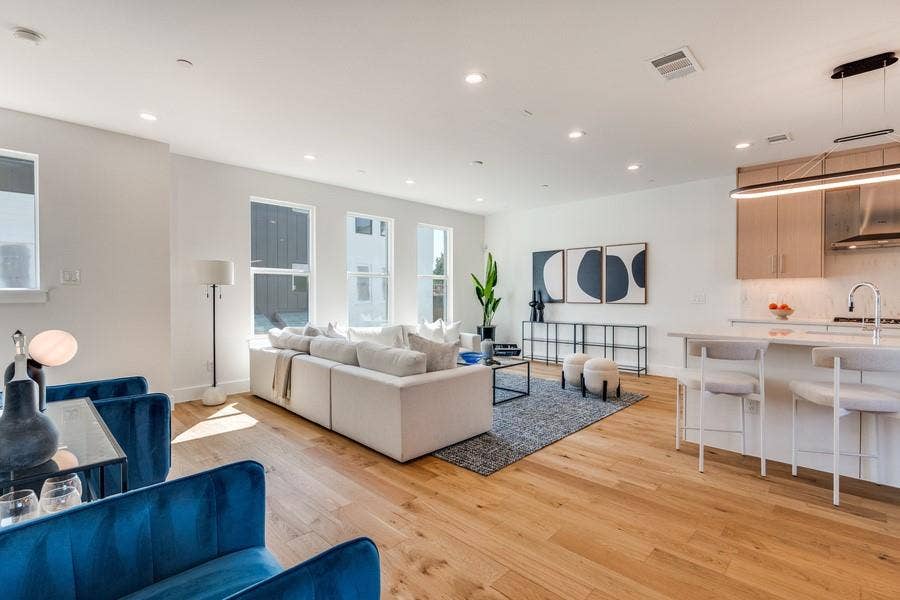 Open-concept interior featuring light wood-finish flooring, recessed lighting, and vertical windows