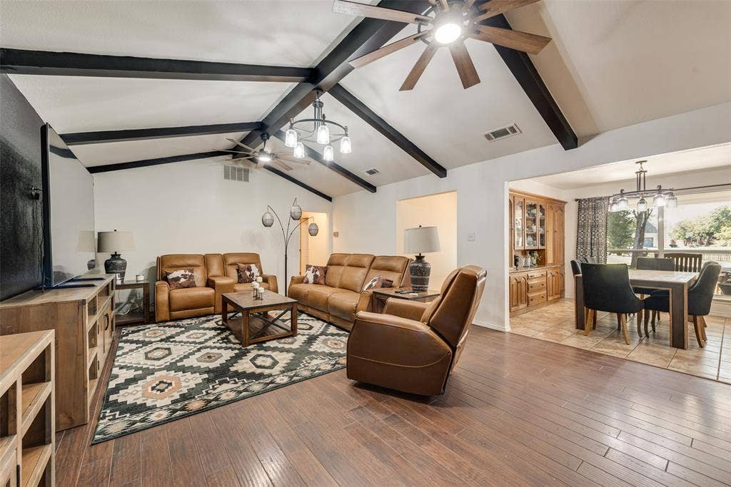 Vaulted ceilings with exposed beams, wood-finish flooring, and built-in wooden cabinetry