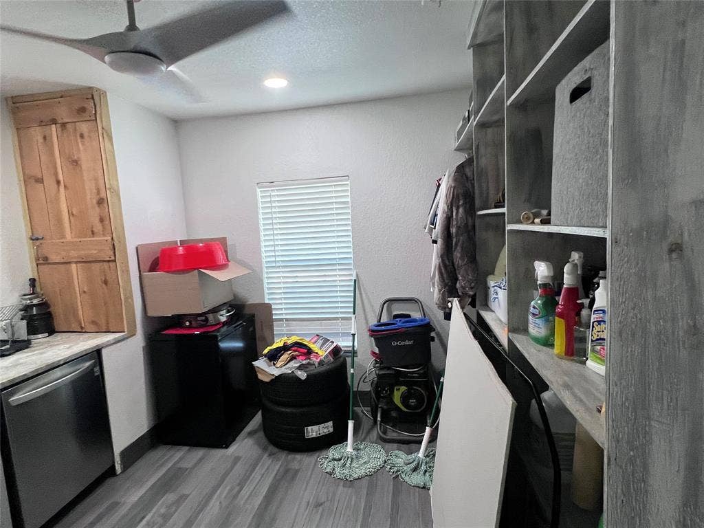 201 Darien Drive, Mesquite, TX 75149 Multi-level wooden shelving, wood-finish flooring, ceiling fan with integrated lighting, and natural wood-toned cabinetry