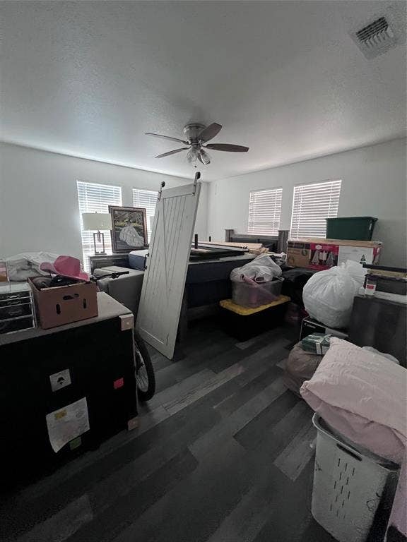 201 Darien Drive, Mesquite, TX 75149 Room featuring wood-finish flooring, four windows with blinds, and a ceiling fan with integrated lighting