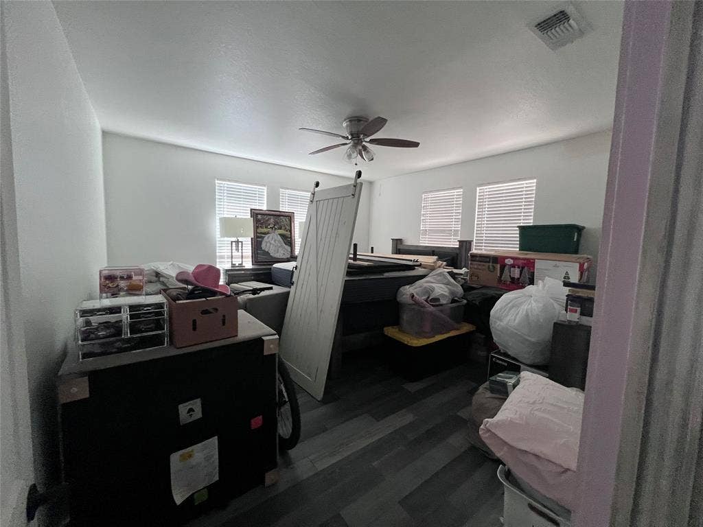 201 Darien Drive, Mesquite, TX 75149 Neutral interior featuring wood-finish flooring, white walls, four windows with horizontal blinds, and a ceiling fan with light fixture