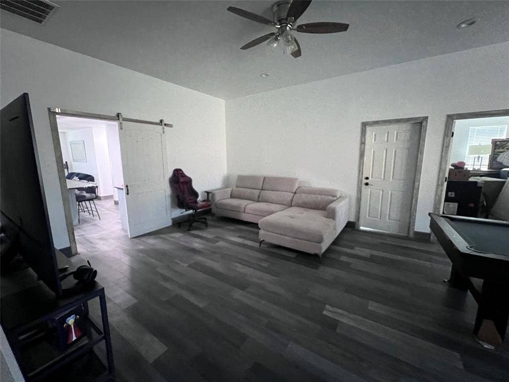 201 Darien Drive, Mesquite, TX 75149 Living space featuring wood-finish flooring, a white sliding barn door, recessed lighting, a ceiling fan with integrated light fixture, and interior doors with decorative trim