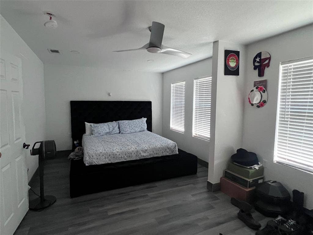 201 Darien Drive, Mesquite, TX 75149 Bedroom featuring wood-finish flooring, three windows with horizontal blinds, and a modern ceiling fan