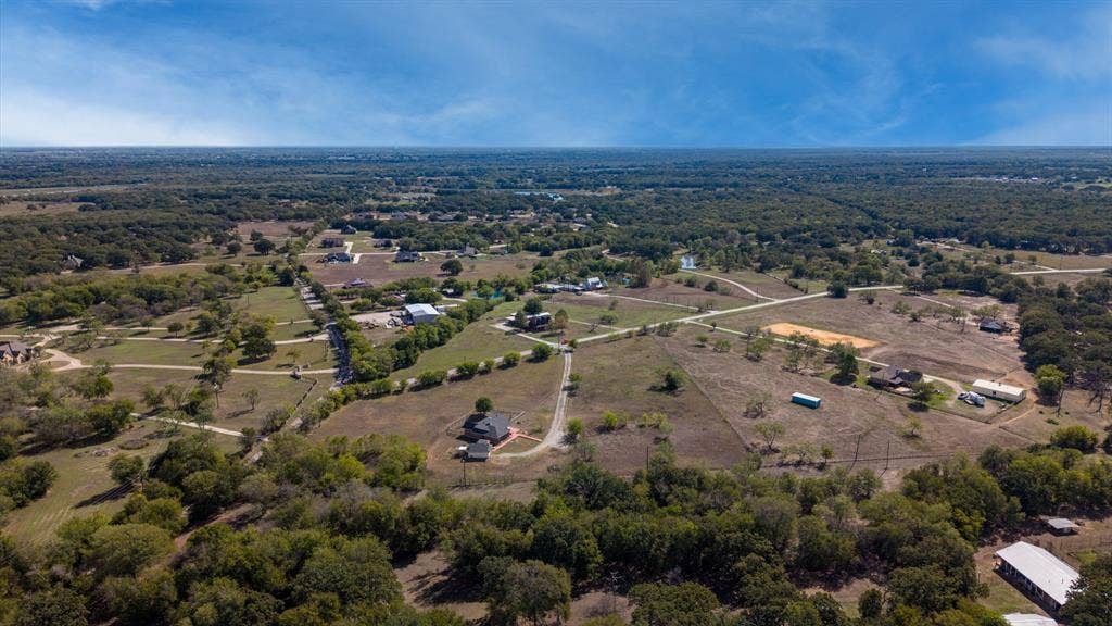 8935 Bluebonnet Drive, Scurry, TX 75158 Aerial perspective featuring expansive acreage, mature tree clusters, and established rural road access