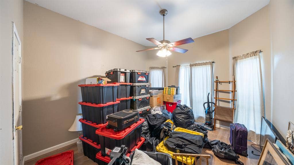 8935 Bluebonnet Drive, Scurry, TX 75158 Room featuring wood-finish flooring, a neutral paint palette, a multi-blade ceiling fan with integrated lighting, and multiple windows