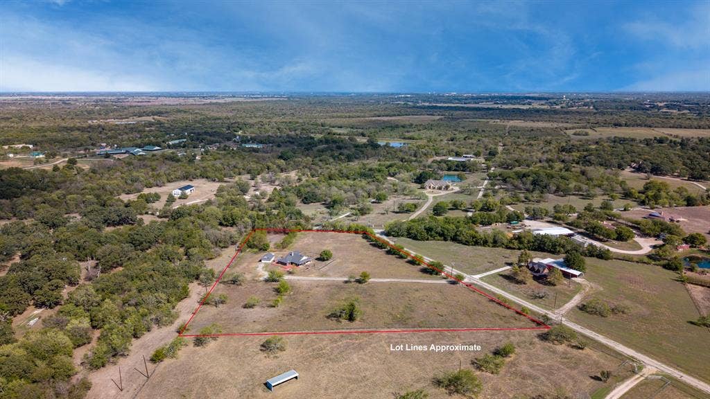 8935 Bluebonnet Drive, Scurry, TX 75158 Expansive acreage featuring mature trees, open pasture, and a gravel driveway