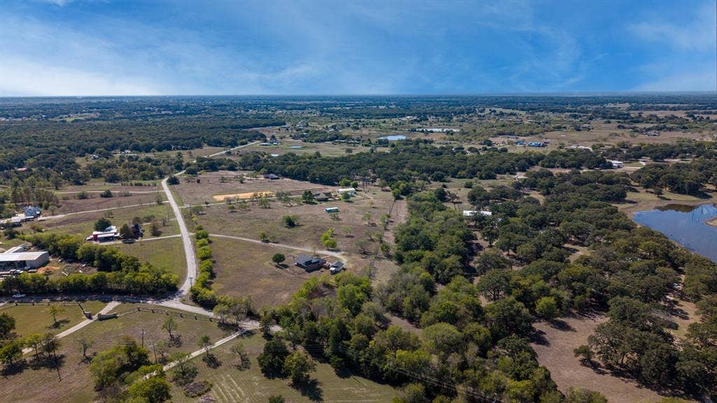8935 Bluebonnet Drive, Scurry, TX 75158 Expansive acreage featuring mature tree clusters, open pasture land, and a natural body of water
