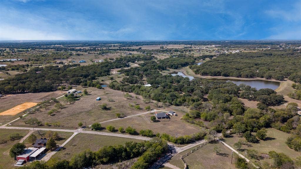 8935 Bluebonnet Drive, Scurry, TX 75158 Expansive acreage featuring mature tree clusters, open pasture land, and a natural pond