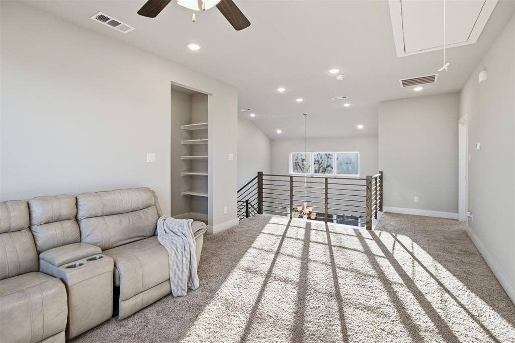 1408 Rockcliff Street, Plano, TX 75093 Vaulted ceilings, recessed lighting, horizontal metal-railing overlook, built-in shelving, and neutral wall-to-wall carpeting
