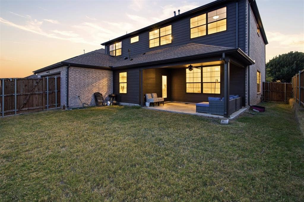 1408 Rockcliff Street, Plano, TX 75093 Two-story exterior featuring a combination of brick and horizontal siding, a covered rear patio, a fenced backyard, and multi-pane windows