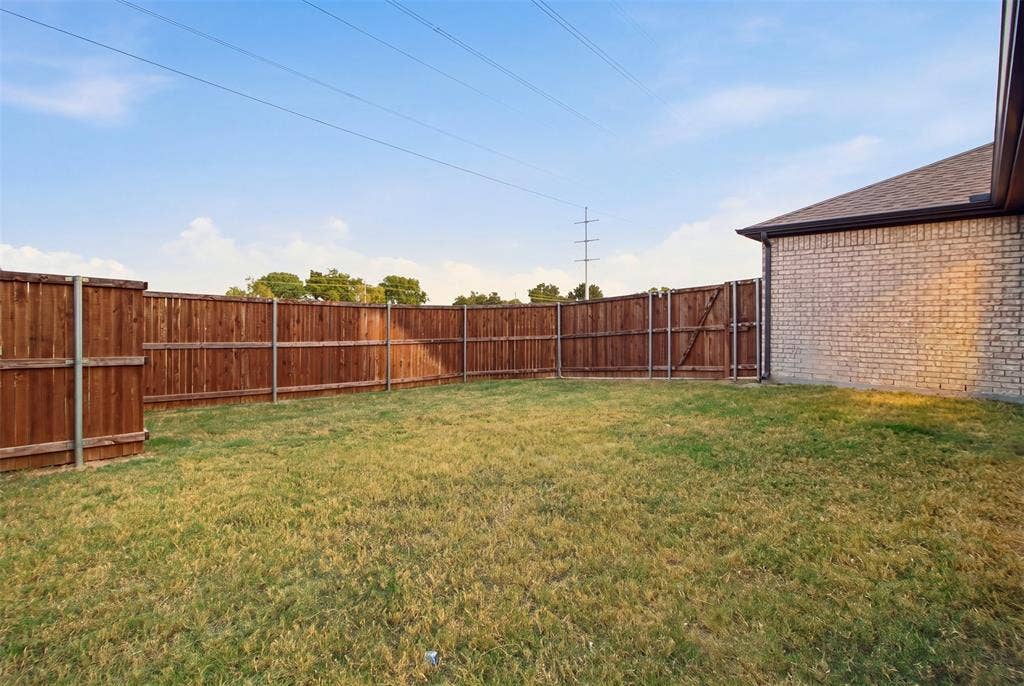 1408 Rockcliff Street, Plano, TX 75093 Backyard featuring a grass lawn, full-perimeter wood privacy fencing, and masonry exterior wall construction