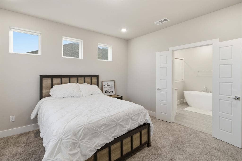 1408 Rockcliff Street, Plano, TX 75093 Neutral-toned interior featuring three high-placed windows, neutral carpeting, recessed ceiling lighting, and double doors opening to a space with a soaking tub
