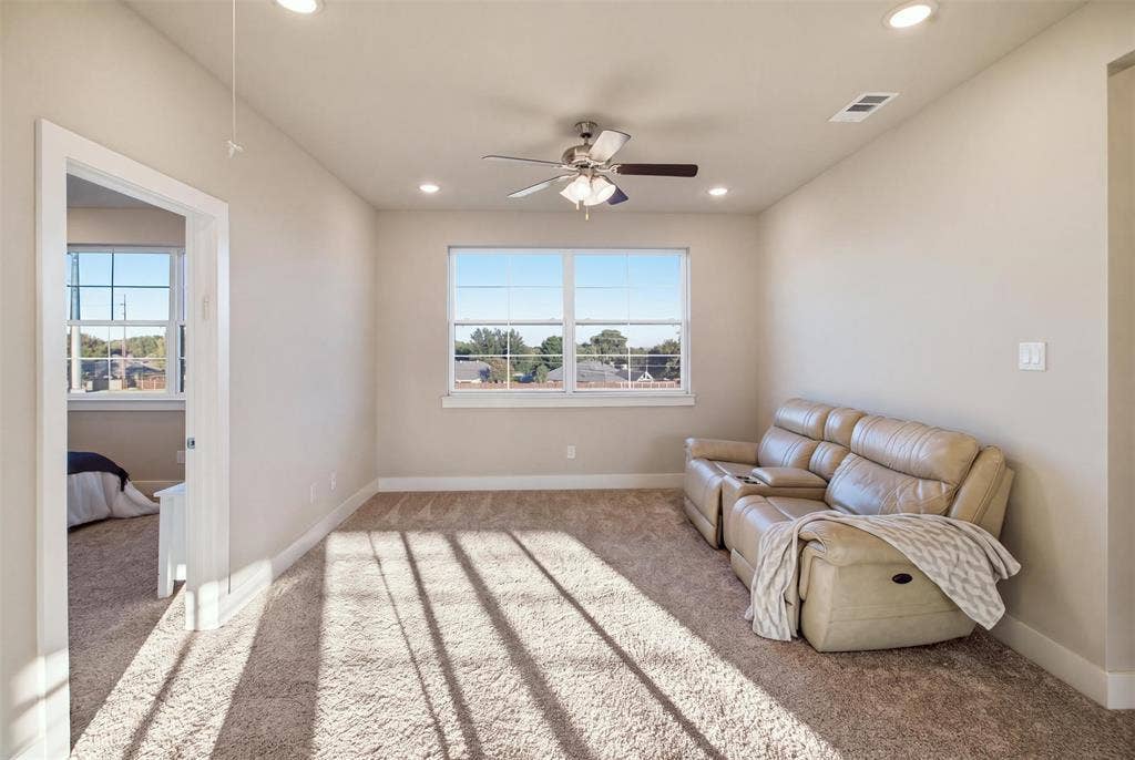 1408 Rockcliff Street, Plano, TX 75093 Neutral-toned carpeted interior featuring recessed lighting, a ceiling fan with integrated light fixture, and windows with white muntins