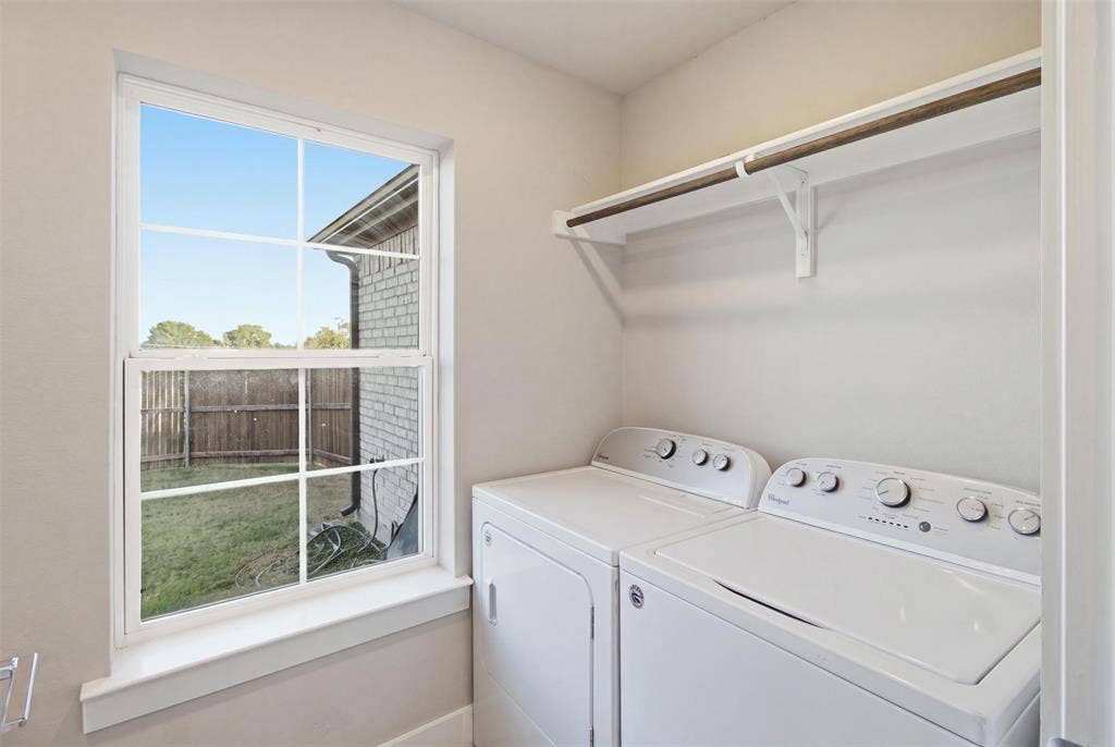 1408 Rockcliff Street, Plano, TX 75093 Utility space featuring a multi-pane window, white-finish built-in shelving, and white-finish laundry appliances