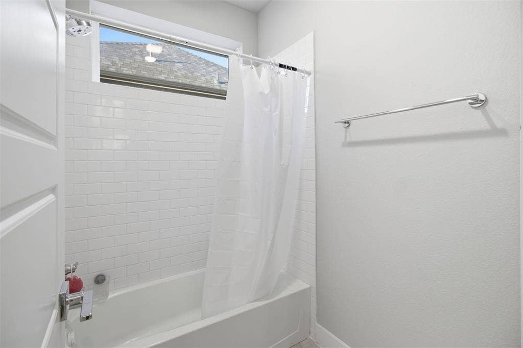 1408 Rockcliff Street, Plano, TX 75093 Tub and shower combination featuring white subway tile surround, high-set horizontal window, and polished chrome hardware