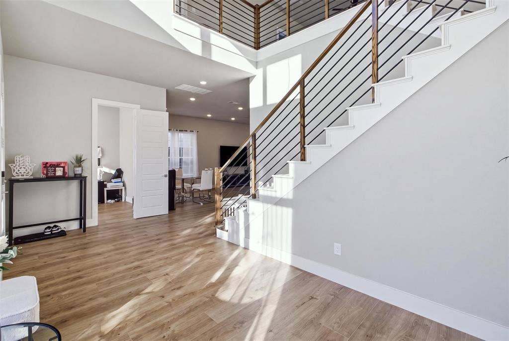 1408 Rockcliff Street, Plano, TX 75093 Two-story foyer featuring wood-finish flooring, a staircase with metal horizontal balusters, a wooden handrail, and recessed lighting