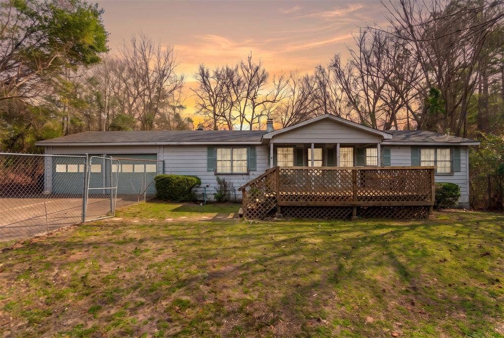 Single-story residence featuring horizontal siding, a covered front porch with lattice skirting, and an attached two-car garage