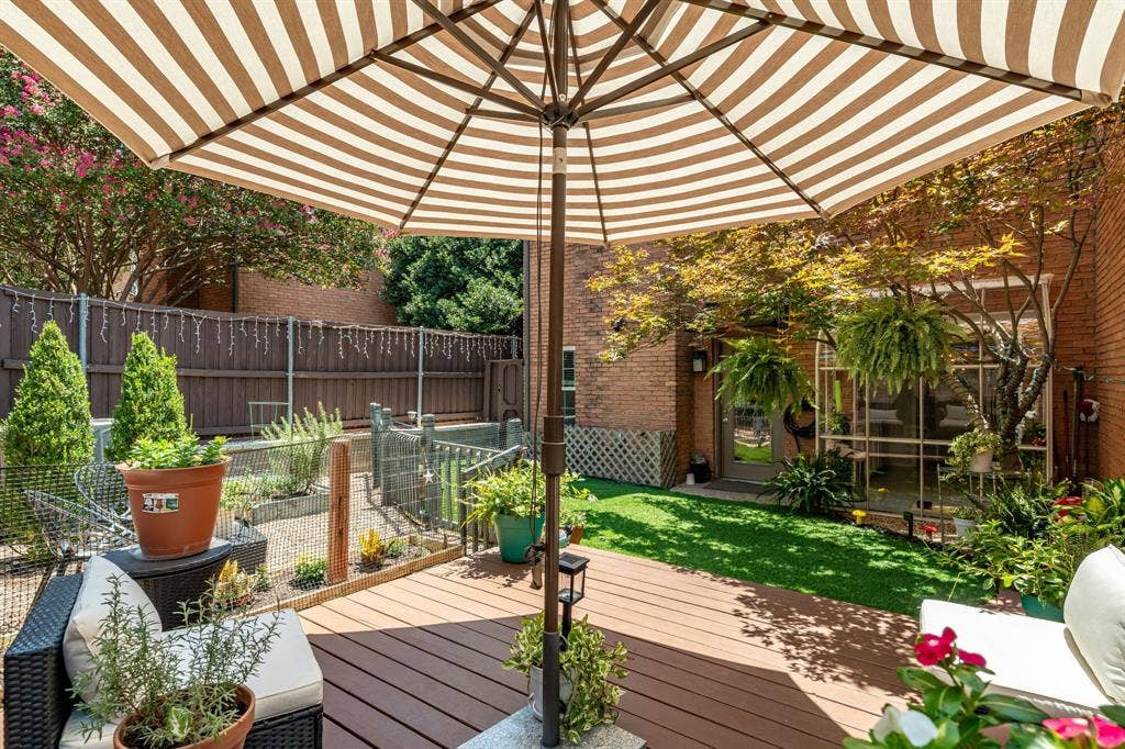 17365 Remington Park Circle, Dallas, TX 75252 Private backyard featuring a composite deck, synthetic lawn, brick exterior siding, and perimeter privacy fencing