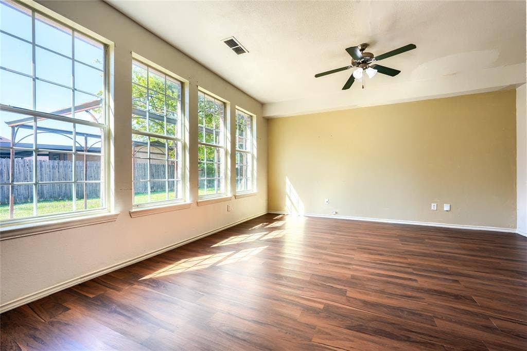 2709 Maci Court, Seagoville, TX 75159 Spacious room featuring wood-finish flooring, a ceiling fan with integrated lighting, and multiple large windows