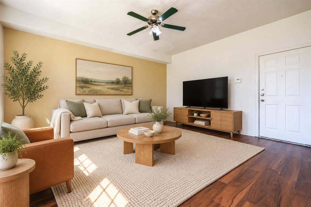2709 Maci Court, Seagoville, TX 75159 Living area featuring wood-finish flooring, a neutral-toned accent wall, and a multi-blade ceiling fan with integrated lighting