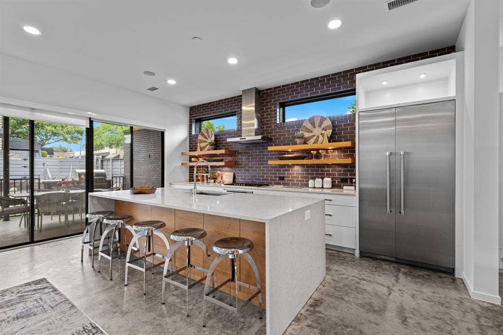 A built-in refrigerator, abundant cabinetry, and an oversized island make this kitchen as functional as it is striking.