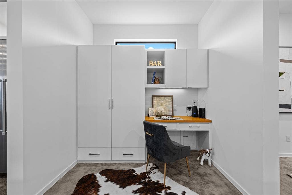 A built-in desk and generous storage create an organized hub for your kitchen pantry with a doggy door hidden underneath leading to the gated dog run.