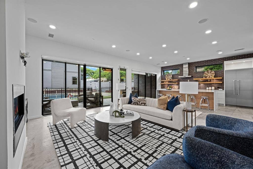 Expansive glass sliders connect the living room and kitchen to the covered terrace and backyard beyond.