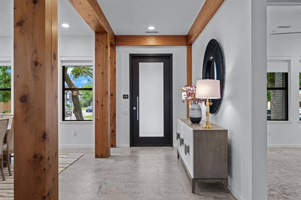 A memorable welcome: substantial wood beams, clean lines, and expensive concrete floors.