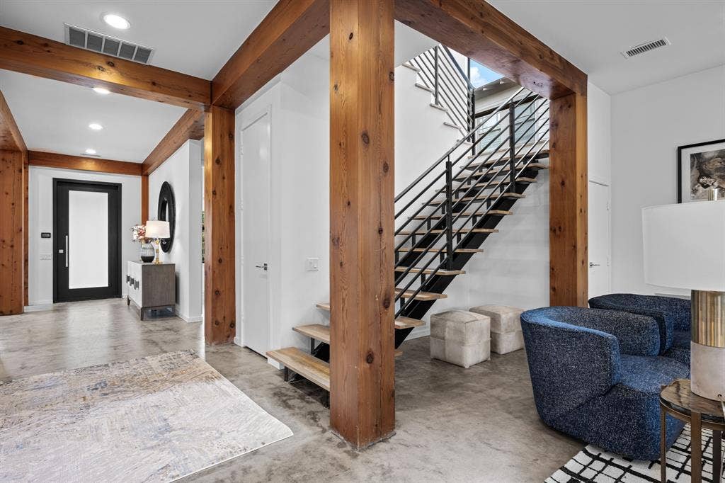 Open wood beams and columns and black metal railings turn the staircase into an architectural centerpiece.