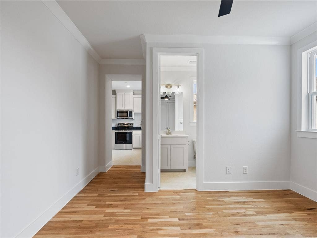 Interior space featuring wood-finish flooring, crown molding, and a neutral color palette