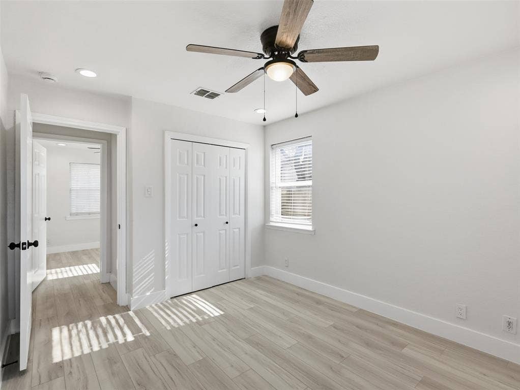 Neutral wall paint, wood-finish flooring, ceiling fan with integrated lighting, recessed lighting, and white six-panel closet doors