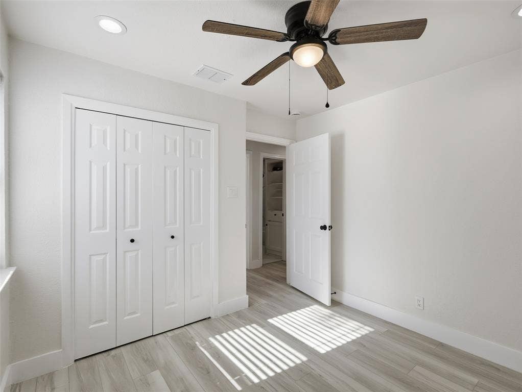Room featuring wood-finish flooring, recessed lighting, a ceiling fan with integrated lighting, and a multi-panel closet door