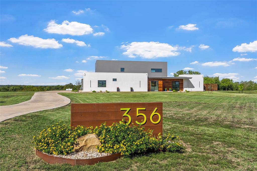 356 Bold Springs Court, West, TX 76691 Contemporary exterior featuring white exterior, horizontal wood-finish accents, and a concrete driveway.