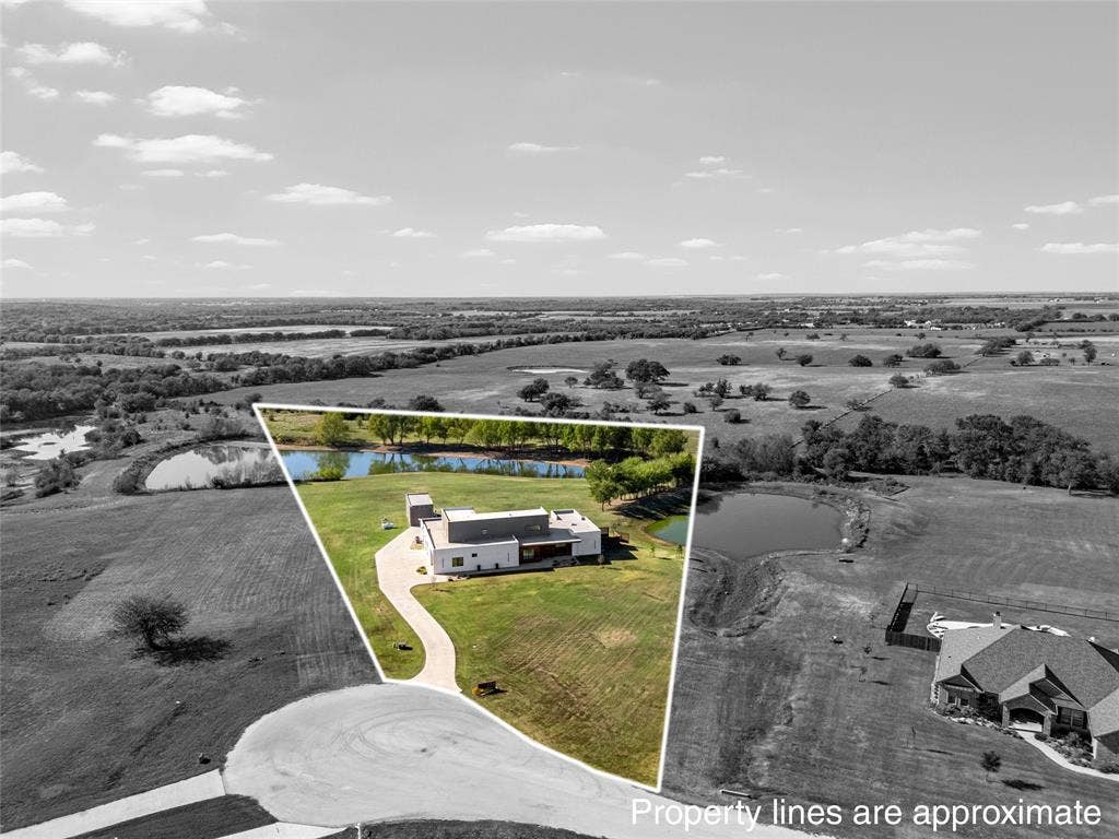 356 Bold Springs Court, West, TX 76691 Aerial view of a sprawling property featuring a modern residence, two stock ponds, a concrete driveway, and expansive acreage