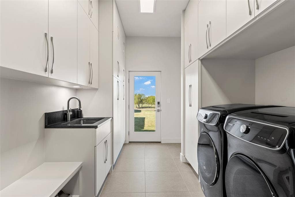 356 Bold Springs Court, West, TX 76691 Utility room featuring floor-to-ceiling white cabinetry, Quartzite surface countertop with undermount sink, sleek metal hardware, and 24 inch tile flooring