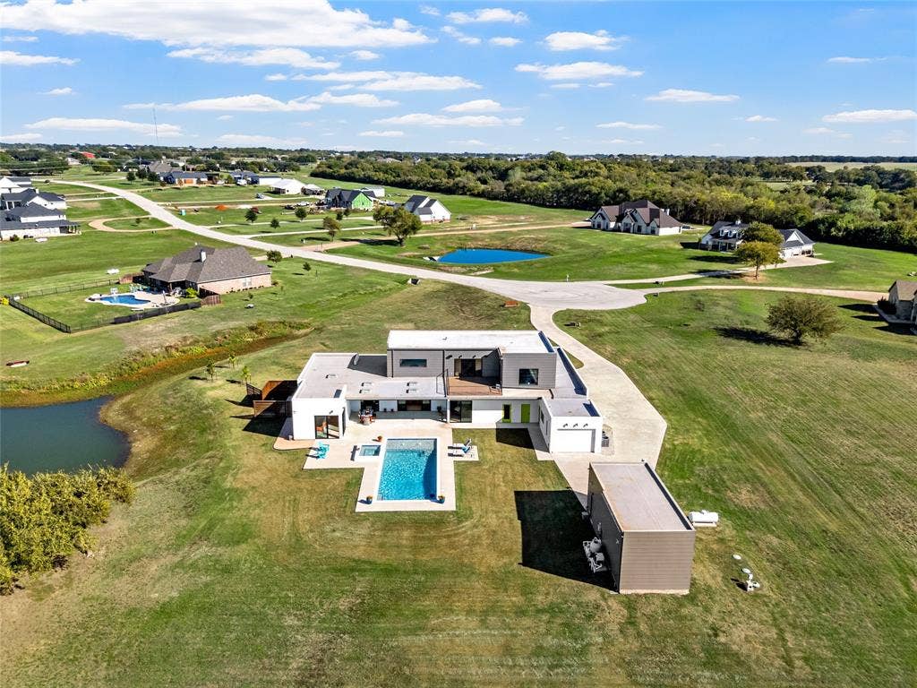 356 Bold Springs Court, West, TX 76691 Contemporary multi-level exterior featuring flat roof lines, a rectangular swimming pool with integrated spa, concrete hardscaping, and a detached RV/Boat garage in addition to 3 car attached garage and 1 car workshop garage.