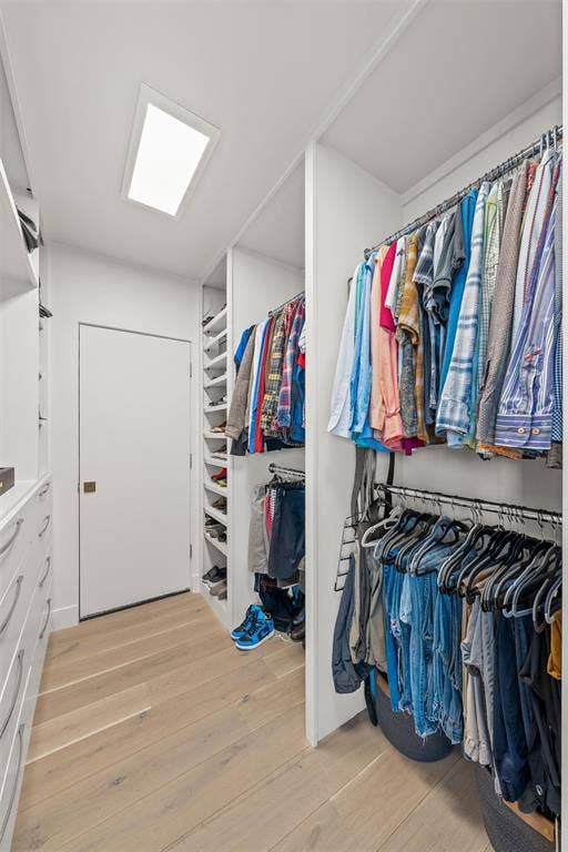 356 Bold Springs Court, West, TX 76691 Walk-in 2-sided closet featuring custom white built-in shelving, multi-level hanging rods, integrated drawer storage, wood-finish flooring, and a recessed ceiling light with mechanical storage and potential safe room