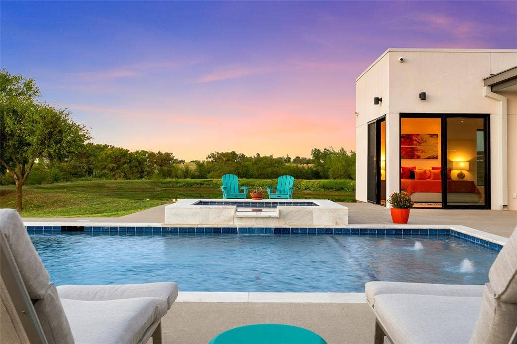 356 Bold Springs Court, West, TX 76691 Stucco exterior residence featuring an in-ground pool, elevated spa with spillway, concrete patio, and large-format sliding glass doors